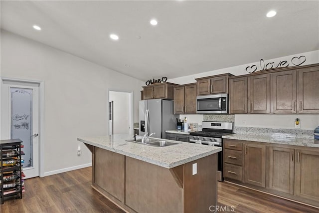 2289 Kyla Ct, San Bernardino, CA 92410 - kitchen featuring appliances with stainless steel finishes, vaulted ceiling, a kitchen island with sink, dark wood finished floors, and a sink