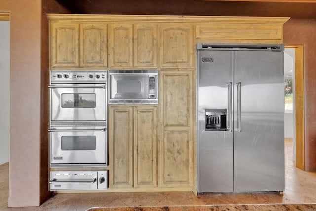 kitchen featuring appliances with stainless steel finishes, a warming drawer, and light brown cabinets