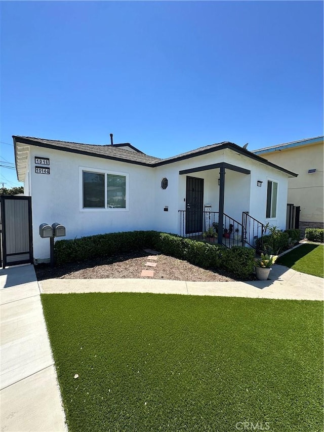 ranch-style house featuring stucco siding and a front yard
