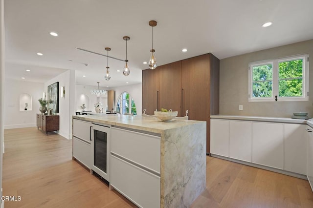 620 S Allen Ave, San Marino, CA 91108 - kitchen with wine cooler, white cabinetry, light wood finished floors, recessed lighting, and pendant lighting