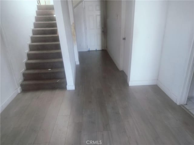 stairway featuring wood finished floors and baseboards