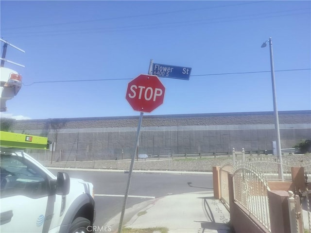 view of asphalt street with curbs and traffic signs