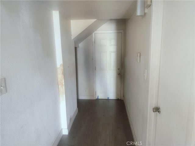 hall with baseboards and wood finished floors