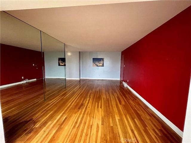 empty room featuring hardwood / wood-style flooring and baseboards