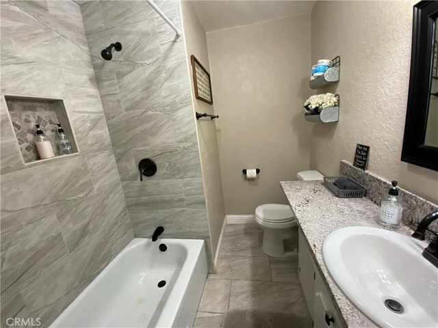 bathroom featuring toilet, vanity, bathing tub / shower combination, and baseboards