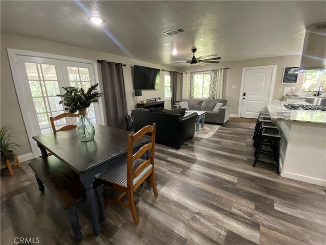 dining room featuring ceiling fan, dark wood-style floors, baseboards, french doors, and a textured ceiling