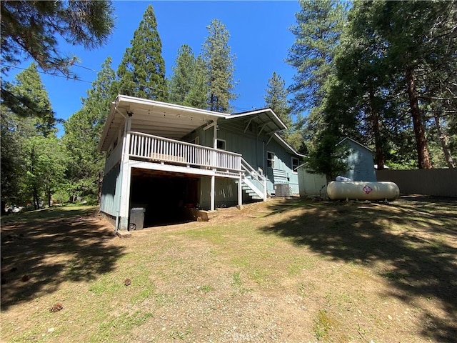 back of property with stairway, a wooden deck, and board and batten siding