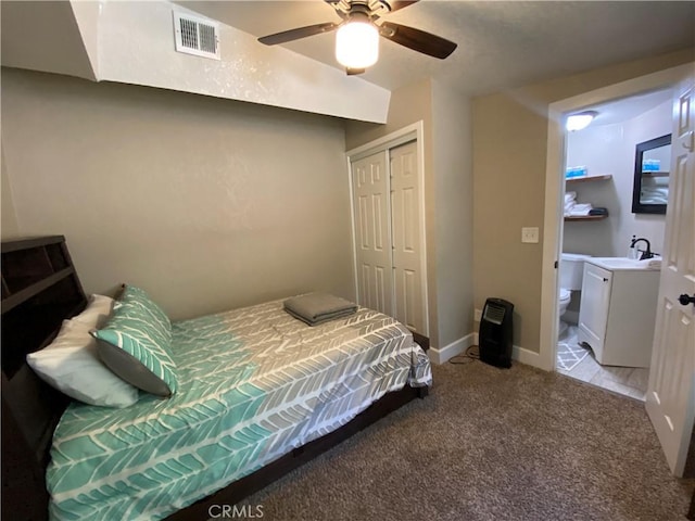 bedroom with light colored carpet, a sink, a closet, baseboards, and ceiling fan