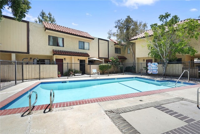 community pool featuring fence and a patio