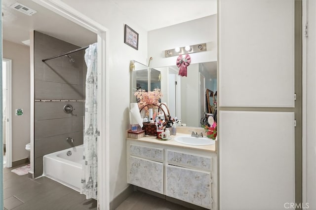 bathroom featuring vanity, shower / tub combo with curtain, toilet, wood finished floors, and baseboards