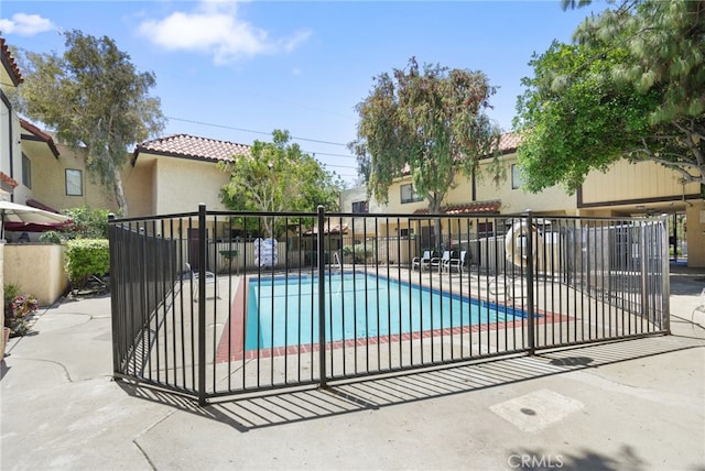 community pool featuring fence and a patio