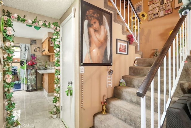staircase featuring tile patterned floors and a textured ceiling