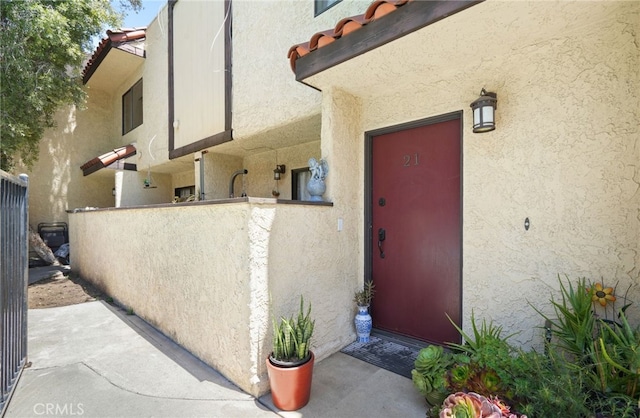 entrance to property with stucco siding and fence