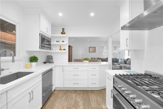 5314 E 4th St, Long Beach, CA 90814 - kitchen with wall chimney exhaust hood, appliances with stainless steel finishes, a sink, light wood finished floors, and recessed lighting