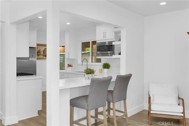 5314 E 4th St, Long Beach, CA 90814 - kitchen featuring refrigerator, stainless steel microwave, white cabinets, recessed lighting, and light wood-style floors