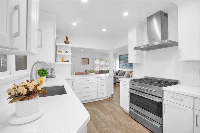 5314 E 4th St, Long Beach, CA 90814 - kitchen with wall chimney range hood, stainless steel gas range oven, open shelves, a peninsula, and light countertops