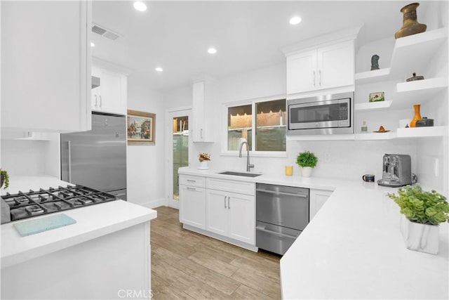 5314 E 4th St, Long Beach, CA 90814 - kitchen with stainless steel appliances, a sink, open shelves, light countertops, and white cabinets