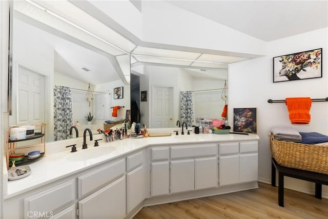 10693 Berrywood Cir, Yucaipa, CA 92399 - bathroom with vaulted ceiling, tiled shower, double vanity, and wood finished floors