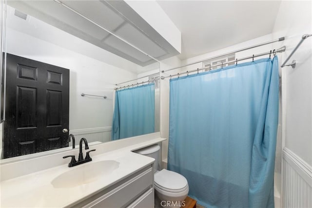 10693 Berrywood Cir, Yucaipa, CA 92399 - full bath with vanity, toilet, shower / tub combo with curtain, and a wainscoted wall
