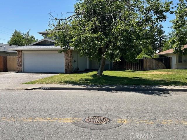 2729 Ceres Ave, Chico, CA 95973 - obstructed view of property with concrete driveway, a garage, and stone siding