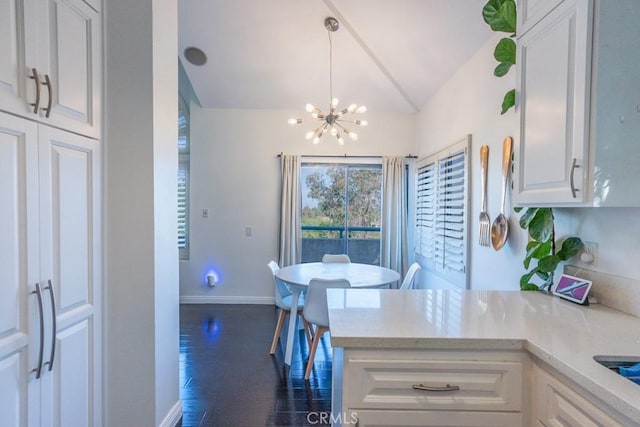 18213 Flynn Dr Unit 132, Canyon Country, CA 91387 - kitchen with lofted ceiling, a chandelier, white cabinets, baseboards, and dark wood-style floors