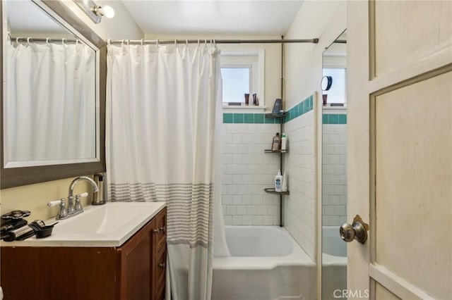 full bathroom with vanity, shower / tub combo, and a wainscoted wall