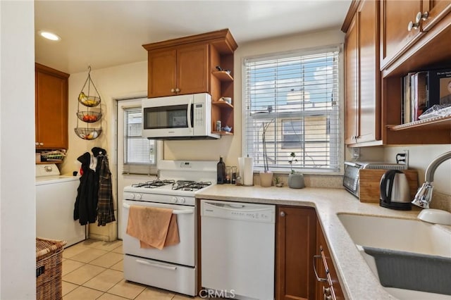 kitchen with white appliances, a sink, washer / clothes dryer, open shelves, and light tile patterned floors