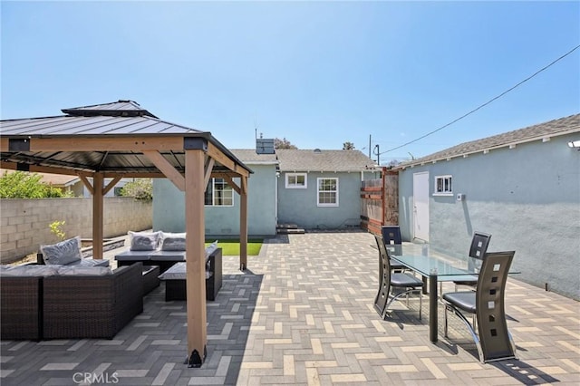 view of patio with an outdoor living space, a fenced backyard, a gazebo, and outdoor dining space