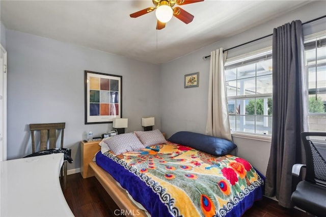 bedroom with dark wood-type flooring, ceiling fan, and baseboards