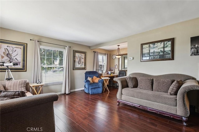 living area featuring plenty of natural light, dark wood-style floors, and baseboards