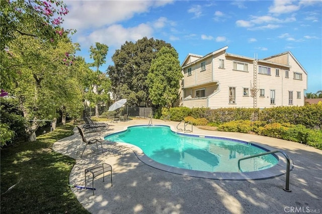 view of pool with a patio area and fence