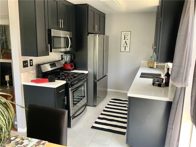 9917 Independence Ave Unit C, Chatsworth, CA 91311 - kitchen featuring stainless steel appliances, a sink, dark cabinetry, and light tile patterned floors