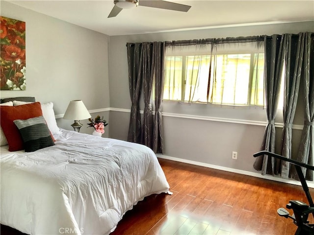 bedroom with baseboards, wood finished floors, and a ceiling fan