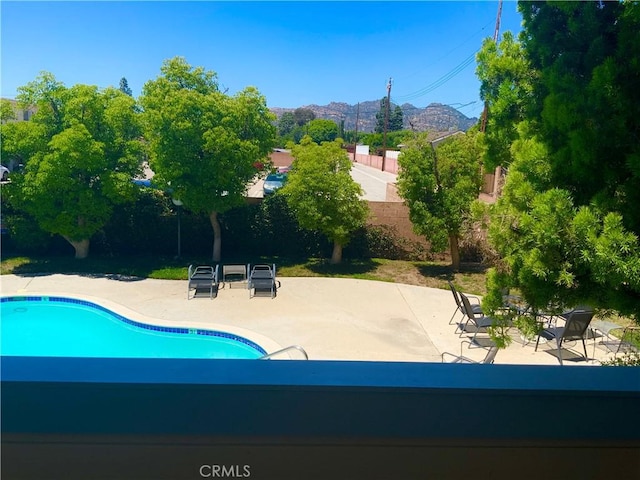 view of pool with a patio, a fenced backyard, and a mountain view