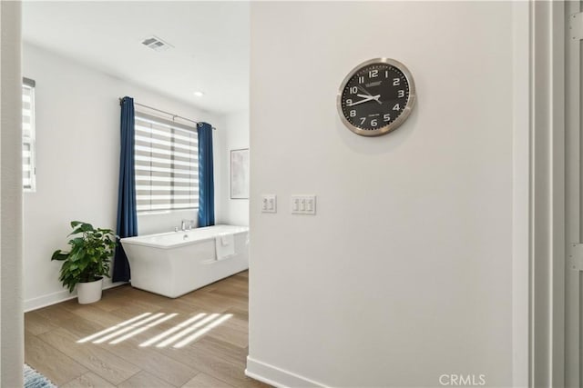 26288 Meadow Dr, San Juan Capistrano, CA 92675 - bathroom featuring wood finished floors, baseboards, and a freestanding bath