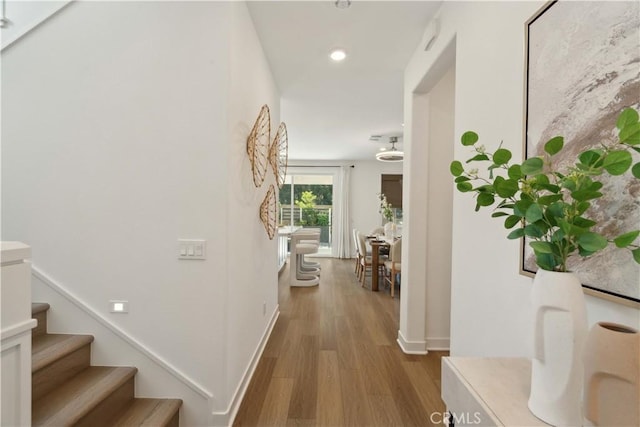 26288 Meadow Dr, San Juan Capistrano, CA 92675 - corridor with wood finished floors, stairway, baseboards, and recessed lighting