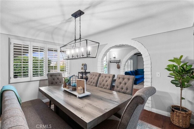 2485 San Mateo Dr, Upland, CA 91784 - dining area featuring wood finished floors, arched walkways, and a chandelier