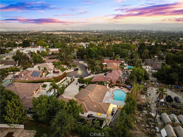 aerial view at dusk of view of pool and a residential view