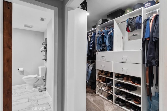 spacious closet with marble look tile flooring