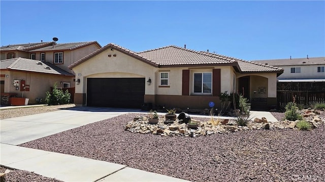 13817 Grant Way, Oak Hills, CA 92344 - mediterranean / spanish-style house featuring stucco siding, an attached garage, concrete driveway, and a tile roof