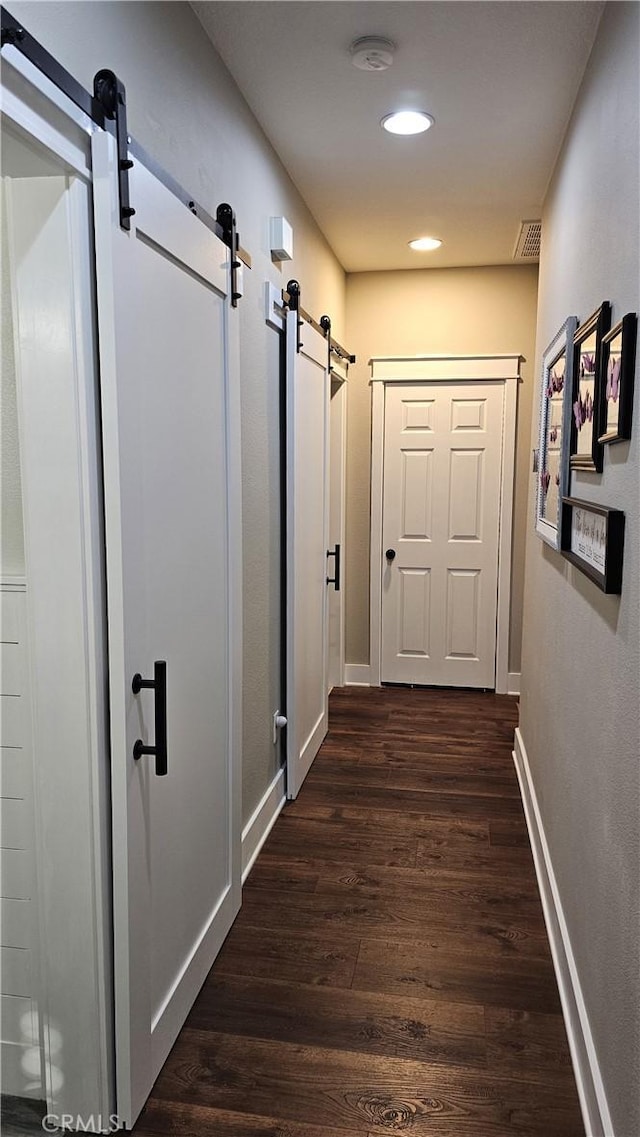 13817 Grant Way, Oak Hills, CA 92344 - hall featuring a barn door, dark wood-style floors, recessed lighting, and baseboards