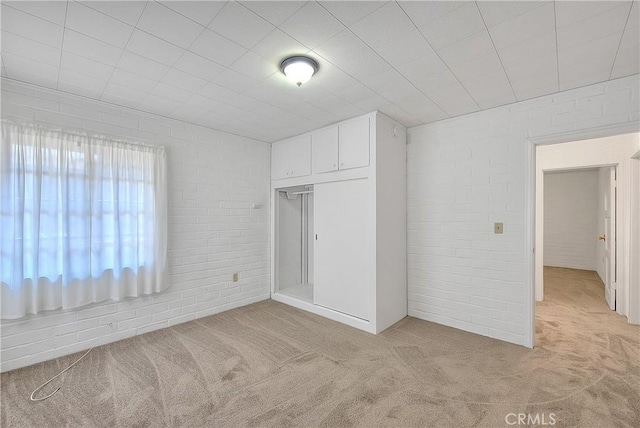 321 Aguirre Ln, Placentia, CA 92870 - unfurnished bedroom featuring light carpet, a closet, and brick wall