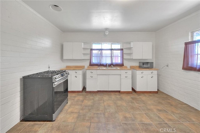 321 Aguirre Ln, Placentia, CA 92870 - kitchen with stainless steel range with gas stovetop, open shelves, black microwave, a sink, and white cabinetry