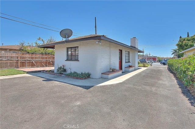 321 Aguirre Ln, Placentia, CA 92870 - view of side of home with a chimney, fence, and a patio area