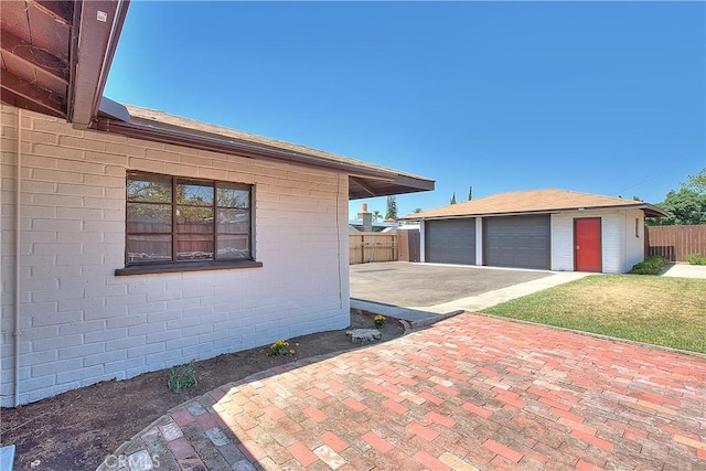 321 Aguirre Ln, Placentia, CA 92870 - view of side of property featuring fence, an outdoor structure, a detached garage, and brick siding