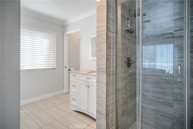 full bath featuring a shower stall, ornamental molding, vanity, and baseboards