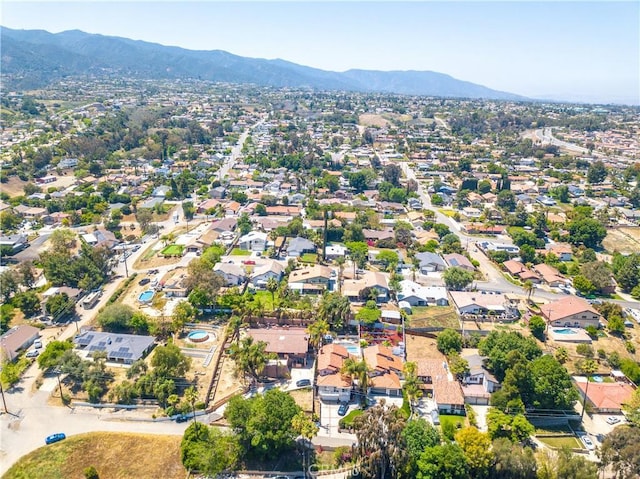 aerial view of property and surrounding area with a mountain backdrop and nearby suburban area