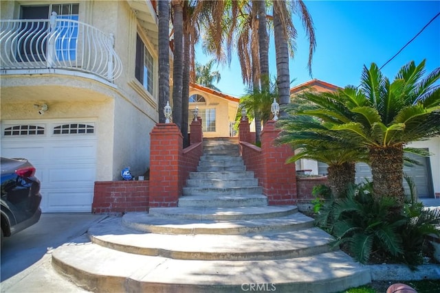doorway to property featuring stucco siding and an attached garage