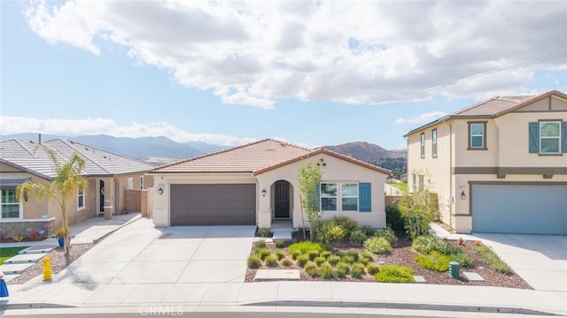 41215 Alegria Ln, Lake Elsinore, CA 92532 - mediterranean / spanish-style home featuring stucco siding, a mountain view, driveway, a tile roof, and an attached garage