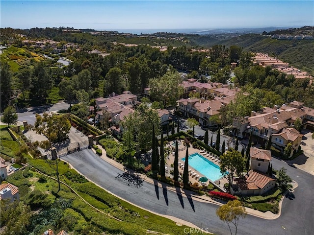 view of property location with a pool and nearby suburban area